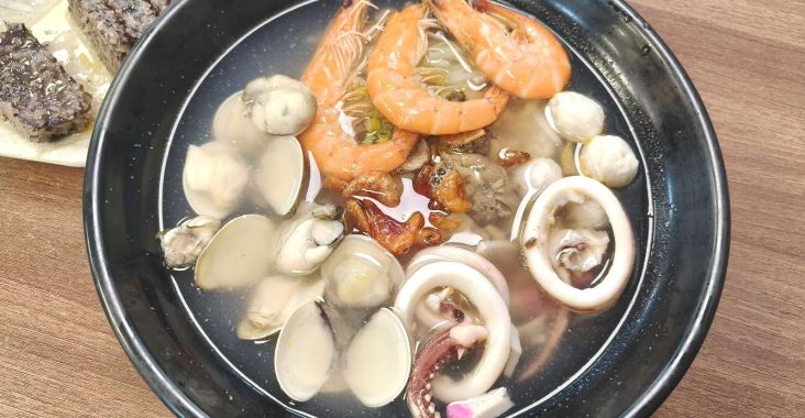 台南歸仁阿宏飯湯的豪華版海鮮飯湯，碗內有鮮蝦、蛤蜊、小卷與魚丸等豐富配料