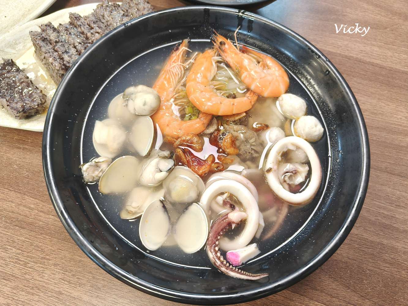 台南歸仁阿宏飯湯的豪華版海鮮飯湯，碗內有鮮蝦、蛤蜊、小卷與魚丸等豐富配料