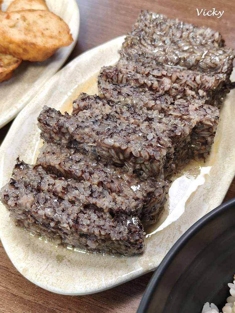 台南阿宏飯湯的台式小菜麻油米血特寫，質地軟糯扎實且黑亮入味