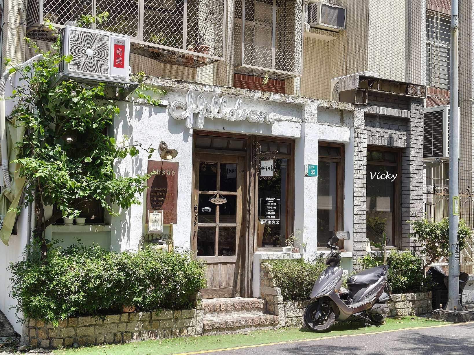 台南東區小孩吃素崇仁店餐廳外觀，白色鄉村風建築搭配木質大門與綠意植栽