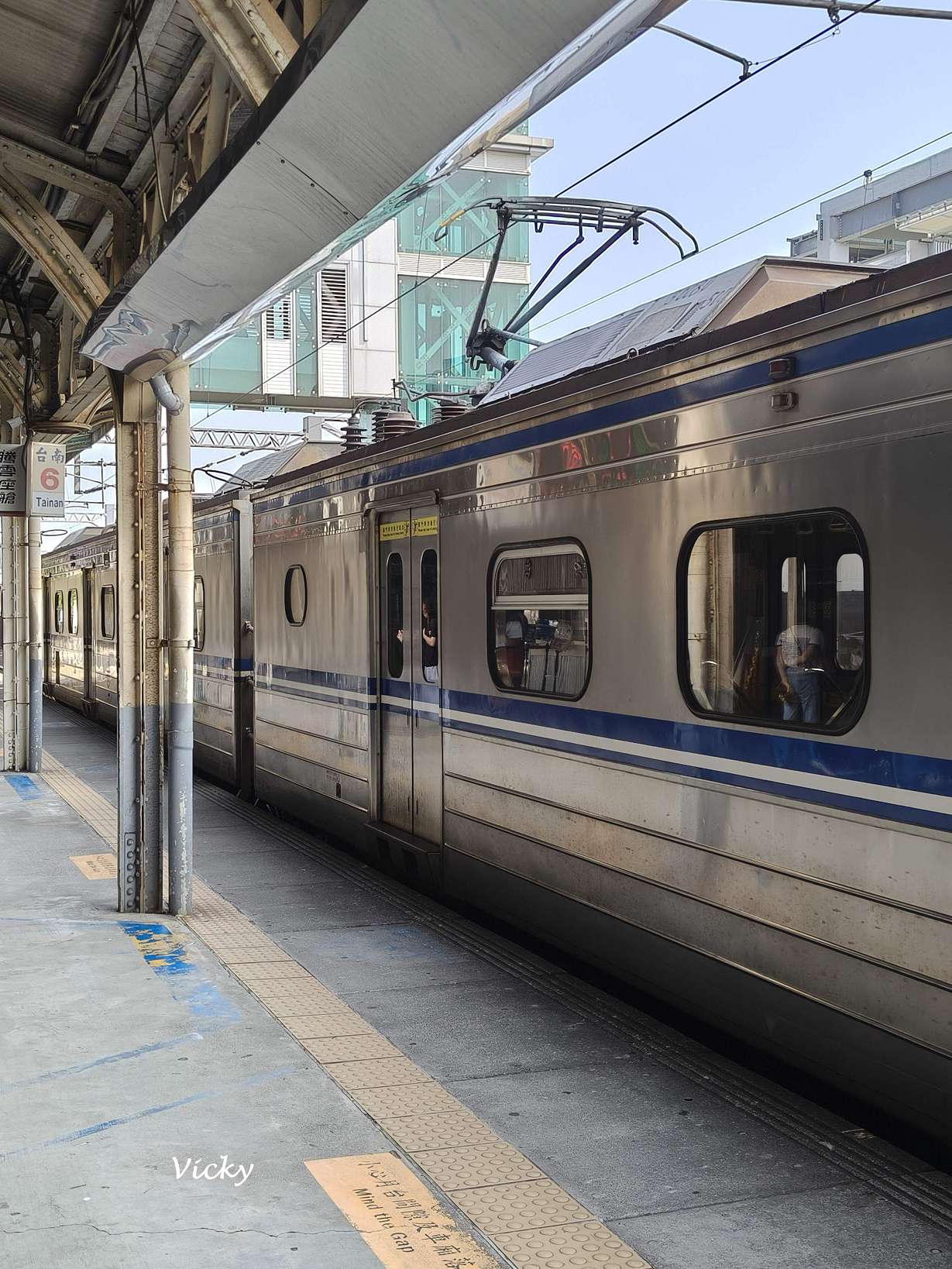 台南火車站舊地面月台與即將走入歷史的跨站天橋,一輛 EMU500 型台鐵火車停靠在復古鋼骨結構月台邊。